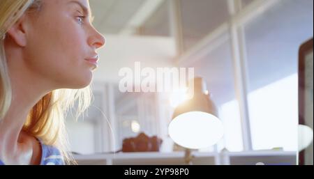 Side view of Caucasian female fashion designer using graphic tablet at desk in office Stock Photo