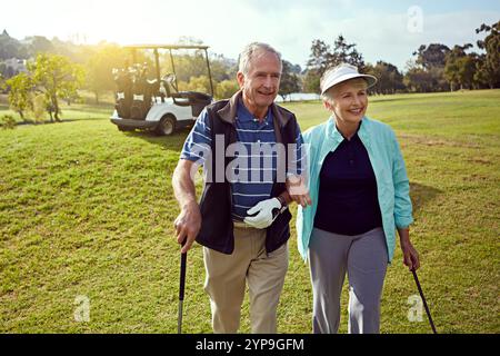 Golf, hobby and walking with senior couple outdoor on green course together for leisure activity. Grass, love and retirement with mature people Stock Photo
