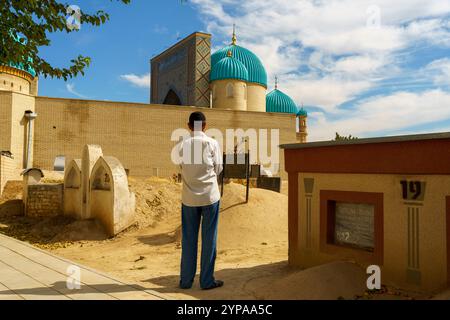 A man is standing in front of a building with a blue dome Stock Photo