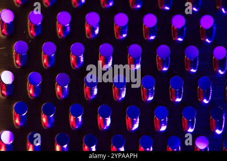 Blue and red light wash on stainless steel perforations Stock Photo