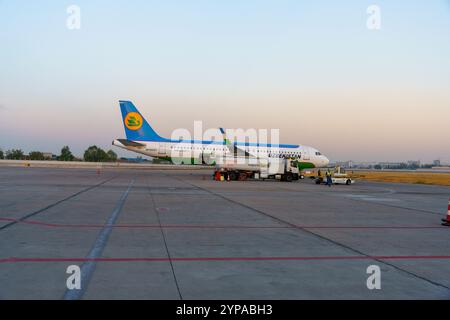 A large airplane is parked on the tarmac with a truck in front of it Stock Photo