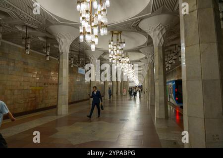 A long, empty subway tunnel with a man walking down it Stock Photo