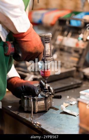 Precision Engineering: A Craftsman Using a Drill on Machinery Components. Stock Photo