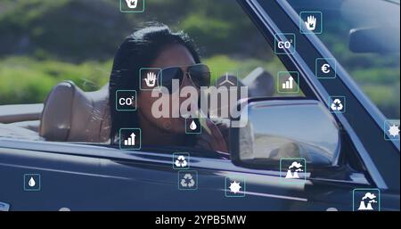 Image of eco icons over biracial woman driving car Stock Photo