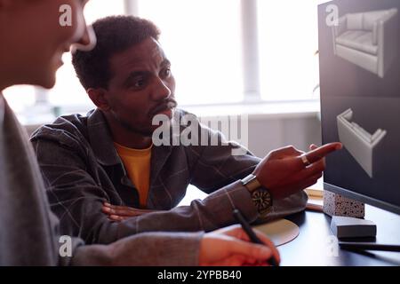 African American man engaging in collaborative design process with colleague, using computer equipment in modern workspace environment enhancing creative productivity Stock Photo