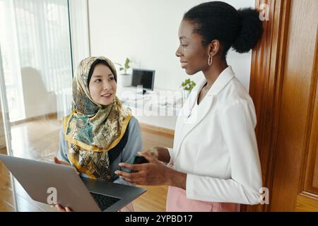 Discussing Project Details with Colleague in Office Stock Photo