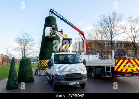 Workers installing a large artificial Christmas tree with a crane truck and hiab in centre square middlesbrough Teesside uk Stock Photo