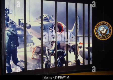 A display showing mechanics working on a Douglas A-4 Skyhawk and a Department of the Navy for the United States of America sign on old film. Stock Photo