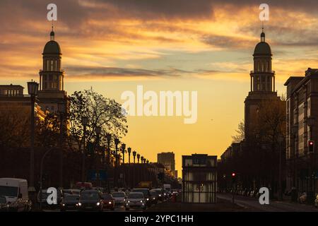 Berlin erwacht: Sonnenaufgang am Frankfurter Tor, Aufnahme des Frankfurter Tors bei Sonnenaufgang. Die aufgehende Sonne taucht die Berliner Straßen in warmes Licht. Berlin Berlin Deutschland *** Berlin wakes up Sunrise at Frankfurter Tor, photo of Frankfurter Tor at sunrise The rising sun bathes the streets of Berlin in warm light Berlin Berlin Germany Stock Photo