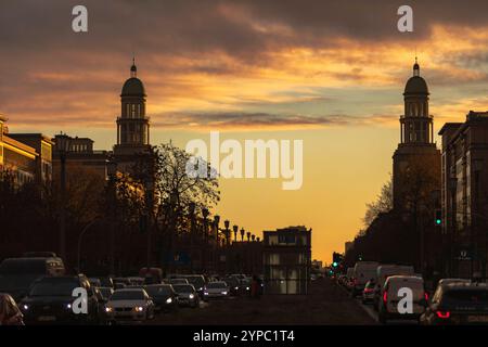 Berlin erwacht: Sonnenaufgang am Frankfurter Tor, Aufnahme des Frankfurter Tors bei Sonnenaufgang. Die aufgehende Sonne taucht die Berliner Straßen in warmes Licht. Berlin Berlin Deutschland *** Berlin wakes up Sunrise at Frankfurter Tor, photo of Frankfurter Tor at sunrise The rising sun bathes the streets of Berlin in warm light Berlin Berlin Germany Stock Photo