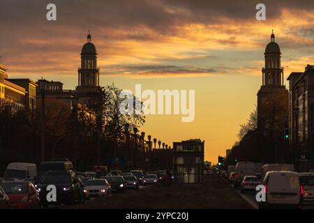 Berlin erwacht: Sonnenaufgang am Frankfurter Tor, Aufnahme des Frankfurter Tors bei Sonnenaufgang. Die aufgehende Sonne taucht die Berliner Straßen in warmes Licht. Berlin Berlin Deutschland *** Berlin wakes up Sunrise at Frankfurter Tor, photo of Frankfurter Tor at sunrise The rising sun bathes the streets of Berlin in warm light Berlin Berlin Germany Stock Photo