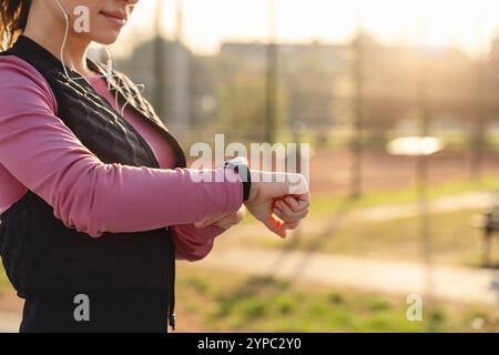 Female athlete using a smartwatch to track her fitness via a mobile app. Stock Photo