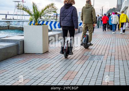 Sochi, Russia - March 17, 2024: Two people ride along the embankment of the city of Sochi on unicycles Stock Photo
