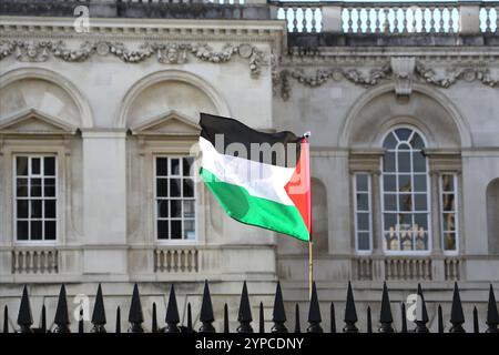 Cambridge, England, UK. 29th Nov, 2024. A Palestinian flag flies at camp at the Senate House. Students from Cambridge University, members of Cambridge for Palestine occupy the Senate House lawn, pitching tents on Wednesday (27th November). They have taken this action in response to Cambridge University's unwillingness to take meaningful action towards divestment from companies that support the Genocide and occupation of Palestine since their last encampment outside Kings College earlier in 2024. Cambridge for Palestine demand an immediate end to the university's complicity in Israel's Stock Photo