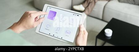 Person using tablet for controlling home automation system while seated on couch in modern living room. Displaying different icons for various home devices Stock Photo