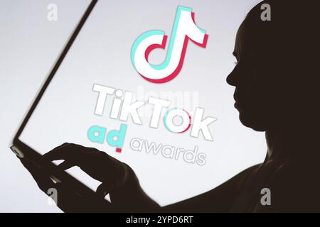 January 24, 2024, Brazil. In this photo illustration, the TikTok Ad Awards logo is seen in the background of a silhouette of a person using a notebook Stock Photo