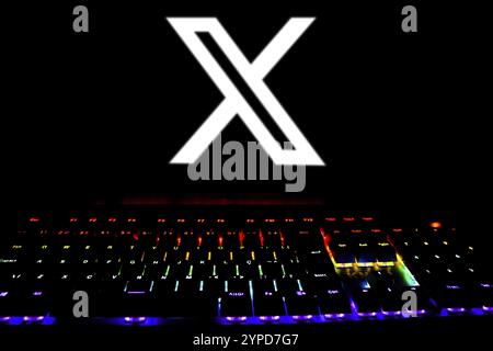 April 17, 2024, Brazil. In this photo illustration, the X (Twitter) logo is displayed on the computer screen with a keyboard of colored lights Stock Photo