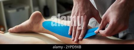 Close-up view of hands applying kinesiology tape on patients leg in clinic setting for muscle support and pain relief Stock Photo