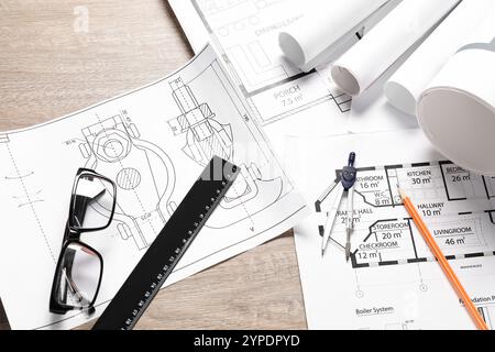 Different engineering drawings, glasses, ruler, pencil and dividers on wooden table Stock Photo