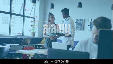 Computer code image over diverse colleagues discussing documents in modern office Stock Photo