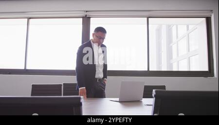 Asian businessman at the office of a creative business, using a laptop computer Stock Photo