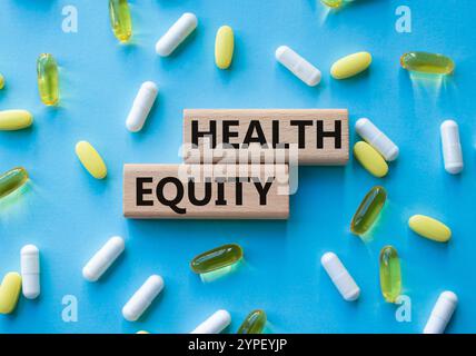 Health Equity symbol. Wooden blocks with words Health Equity. Beautiful blue background with pills. Medicine and Health Equity concept. Copy space. Stock Photo