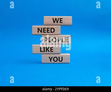 Hiring symbol. Wooden blocks with words We need People like You. Beautiful blue background. Business and Hiring concept. Copy space. Stock Photo
