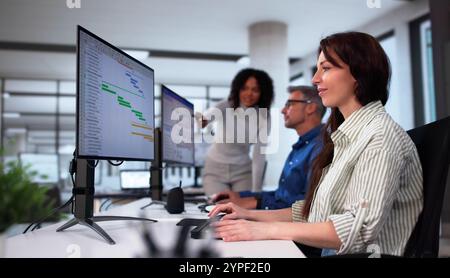 Businesspeople Analyzing Gantt Chart And Calendar On Computer In Office Stock Photo
