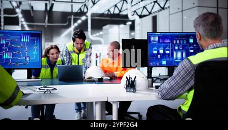 Factory Automation Using Scada System. Diverse Workers Using Control Computers Stock Photo