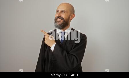 Hispanic man portrait isolated on white background wearing a formal suit and pointing, representing a handsome adult male with a bearded face, bald he Stock Photo