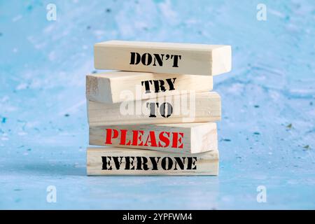 Don't try to please everyone symbol. Concept words Don't try to please everyone on wooden blocks. Beautiful green background, wooden table. Business c Stock Photo
