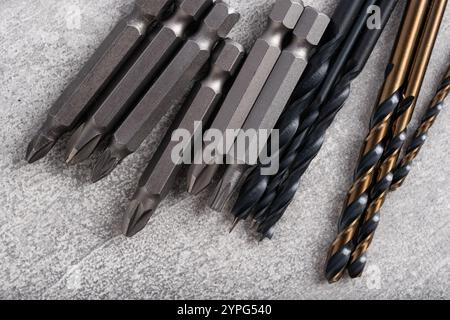Set of different drill bits on grey stone background. Construction tools Stock Photo