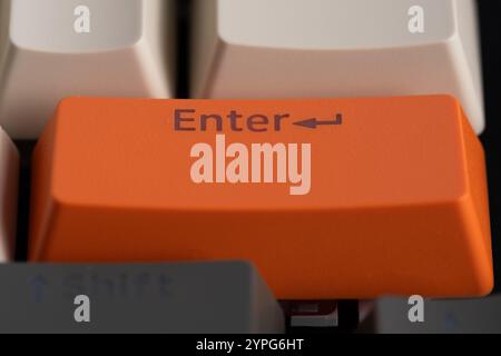 Close up of orange computer keyboard key with Enter button Stock Photo