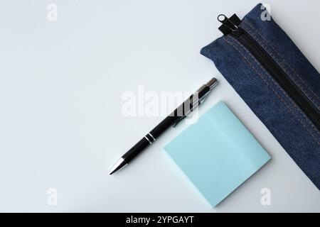 Blue stationery for students, school supplies for academic education. Pen, sticky notes and pencil case isolated on white background with copy space. Stock Photo
