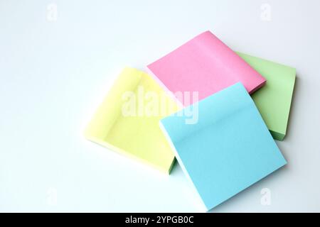 Four sticky notes in pastel colors. Stationery for office, school, home and self reminder. Square adhesive paper pads. Copy space available. Stock Photo