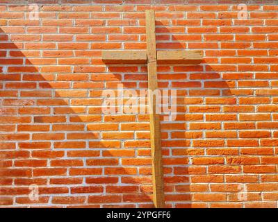 A wooden Catholic cross in front o f a red bricks wall in a patio in San Miguel de las Tetillas, Villa Progreso, Ezequiel Montes, Queretaro, Mexico Stock Photo