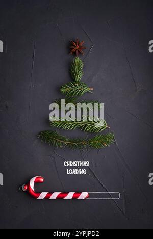 Christmas Loading Concept - Christmas Tree from fir tree twigs and Candy Cane on black background Stock Photo