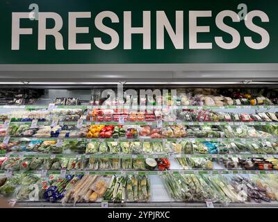 Large wording Freshness. Fresh vegetable layout on shelves in the supermarket for the customer to select. Bright lighting to see clearly.  Singapore. Stock Photo