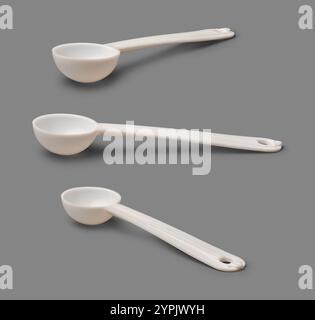 set of small plastic bowl shape spoons with long handle isolated gray background, food grade for measure powdered food, milk protein or supplements Stock Photo