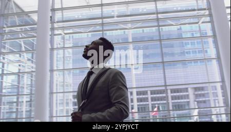 Side view of African American Businessman looking upwards in the lobby at office Stock Photo