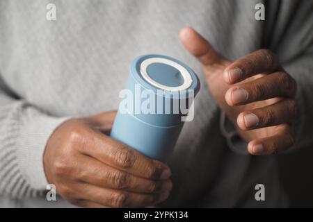 hand holding blue reusable steel stainless thermo water bottle Stock Photo