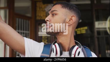 Midsection of biracial man drinking coffee and using smartphone in the street Stock Photo