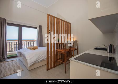 Bedroom and lounge area in luxury studio apartment show home showing interior design decor furnishing with open plan kitchen Stock Photo