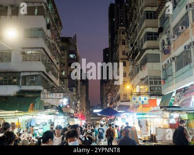 View looking along a busy street market in the Sham Shui Po district of Hong Kong Kowloon at night Stock Photo