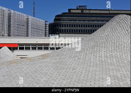 a modern architectural scene, emphasizing a unique, undulating rooftop pattern made of interlocking tiles. The wavy surface creates a visually strikin Stock Photo