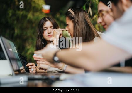 High school friends collaborating on assignments in a cozy coffee shop Stock Photo