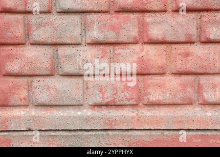 Brick wall with worn red paint, a wall damaged by time and weather. Stock Photo