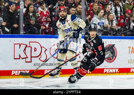 Germany. 01st Dec, 2024. Eishockey Penny-DEL 22.Spieltag Koelner Haie - Schwenninger Wild Wings am 01.12.2024 in der Lanxess Arena in Koeln Thomas Larkin ( Schwenningen ), links - Moritz Mueller ( Koeln ), rechts Gemaess den Vorgaben der DEL Deutsche Eishockey Liga ist die Publikation und Weiterverwertung der Aufnahmen in elektronischen Medien und Endgeraeten aller Art waehrend des laufenden Spiels nicht zulaessig. Foto: Revierfoto Credit: ddp media GmbH/Alamy Live News Stock Photo