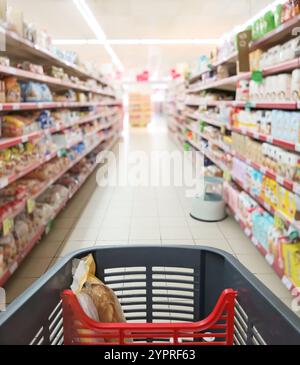 Shopping cart in a supermarket aisle. Stock Photo