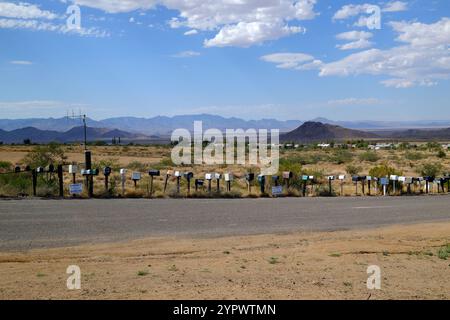 A row of mailboxes along the a road in Arizona with the residences off in the distance Stock Photo